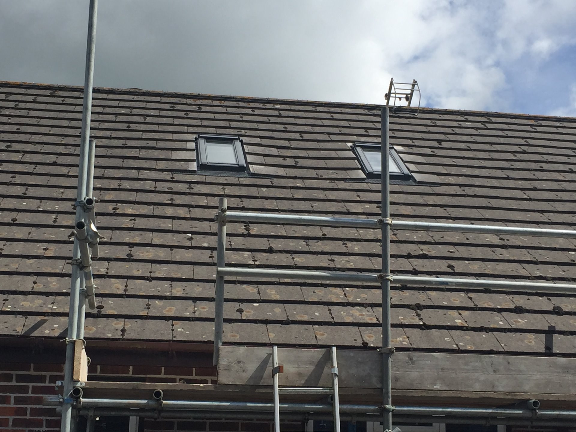 Scaffold was erected as a crash deck, and works were carried out from a roofing ladder. Velux flashing kits were fitted to the windows and the original tiles cut and refitted. in North Devon