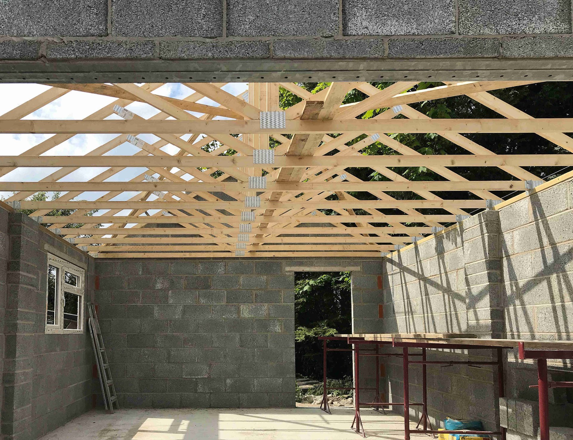 Garage roof truss construction completes, window installed. North Devon