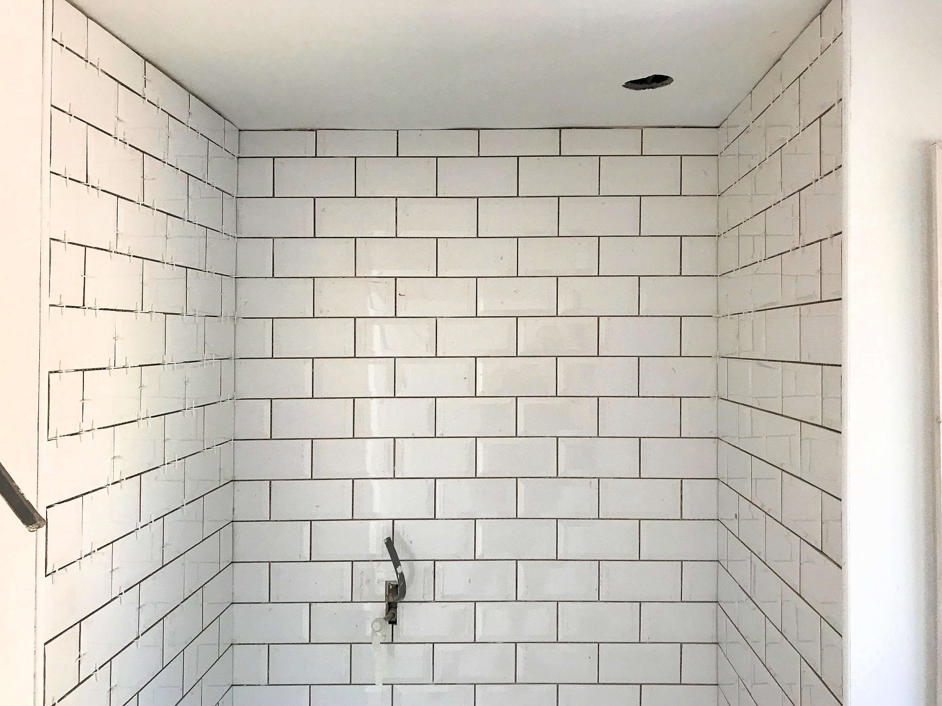 Brick bond tiling using rectangle tiles installed in the new shower area. North Devon