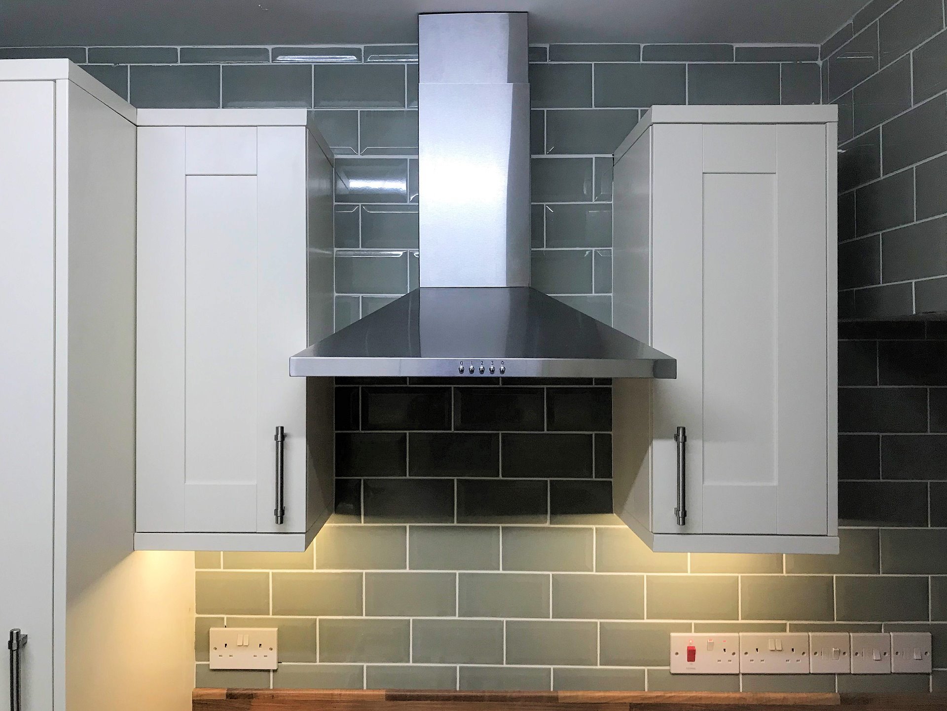 Cooker hood extractor fan with wall hung cabinet units and led lighting installation. Barnstaple North Devon