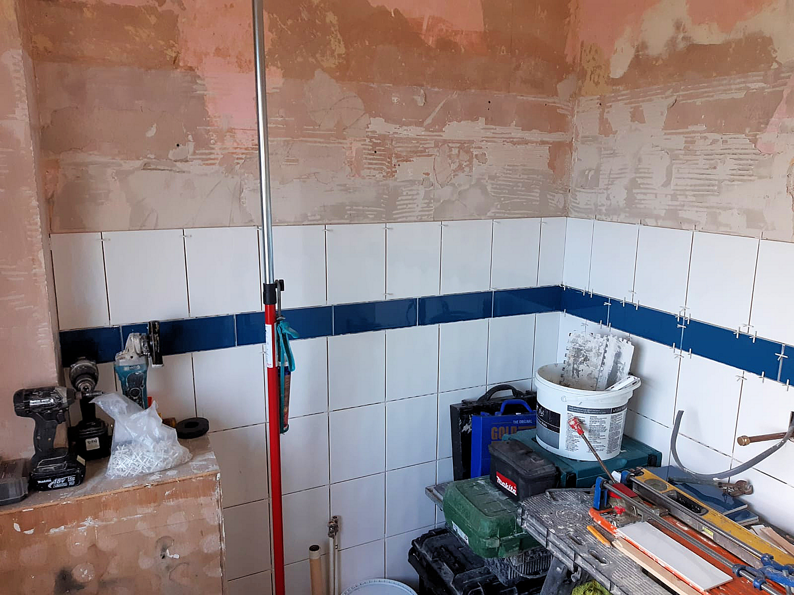 Full height white tiling with a row of vision enhancing contrasting blue tiles at waist height, Barnstaple North Devon